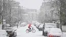 Seorang pengendara sepeda melintasi jalan yang tertutup salju di London barat saat ibu kota Inggris mengalami hujan salju yang jarang terjadi pada Minggu (24/1/2021). Hujan salju langka itu membawa kegembiraan di tengah penguncian atau penutupan wilayah (lockdown) secara nasional (JUSTIN TALLIS/AFP)