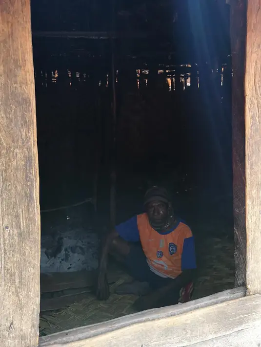 Warga berdiam diri di dalam rumahnya yang gelap di Distrik Puldama, Kabupaten Yahukimo, Provinsi Papua. Sebagai implementasi program Nawa Cita, Kementerian ESDM membagikan gratis Lampu Tenaga Surya Hemat Energi (LTSHE). (Liputan6.com/HO/Hadi M Juraid)