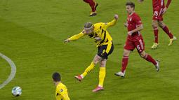 Dortmund sukses membuka keunggulan pada menit ke-2 melalui tembakan Erling Haaland dari luar kotak penalti. 7 menit berselang, Haaland kembali menjebol gawang Bayern Munchen. (Foto: AP/Pool/Guenter Schiffmann)