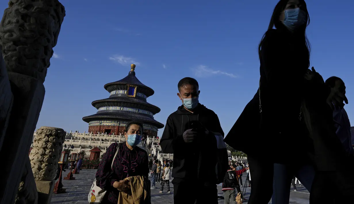 Turis berjalan ke pintu di Kuil Surga pada hari terakhir Hari Nasional China selama seminggu di Beijing, Kamis (7/10/2021). (AP Photo/Andy Wong)