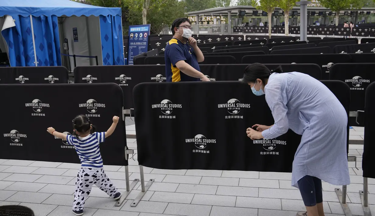 Seorang wanita mengambil foto seorang anak ketika mereka mengunjungi taman hiburan Universal Studios selama uji coba di Beijing (31/8/2021). Perusahaan menetapkan tanggal pembukaan 20 September, menurut pernyataan dan video yang diposting di situs media sosial China WeChat. (AP Photo/Ng Han Guan)