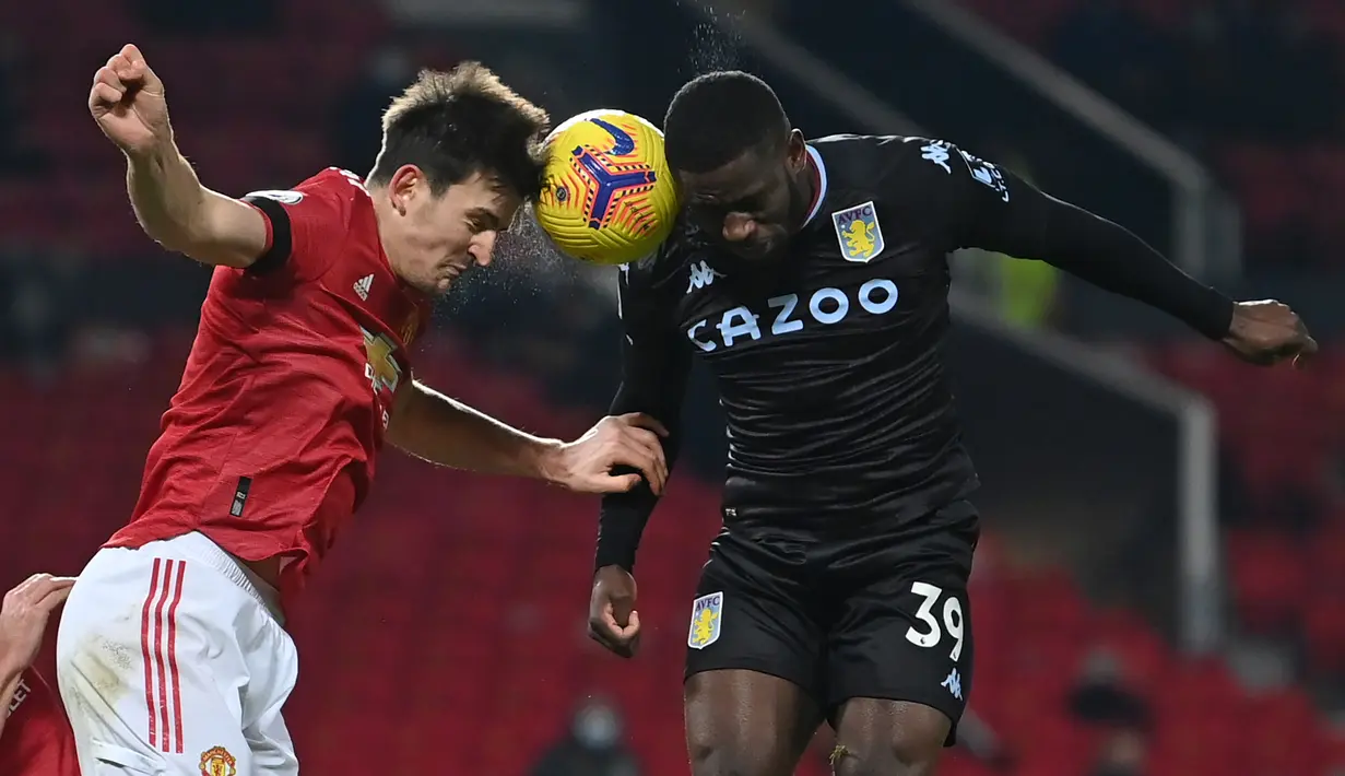 Bek Manchester United, Harry Maguire (kiri) berduel udara dengan striker Aston Villa, Keinan Davis dalam laga lanjutan Liga Inggris 2020/21 pekan ke-17 di Old Trafford, Jumat (1/1/2021). Manchester United menang 2-1 atas Aston Villa. (AFP/Laurence Griffiths/Pool)