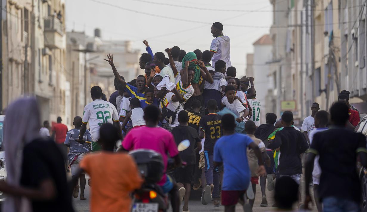 Penggemar klub sepak bola Senegal merayakan kemenangan tim mereka saat melawan Ekuador di laga grup A Piala Dunia 2022 di Qatar, pada layar video yang dipasang di zona penggemar, Dakar, Senegal, Selasa (29/11/2022). Koulibaly menjadi pemain terbanyak yang melakukan clearance dan tampil gemilang dalam babak penyisihan laga grup A. (AP Photo/Leo Correa)