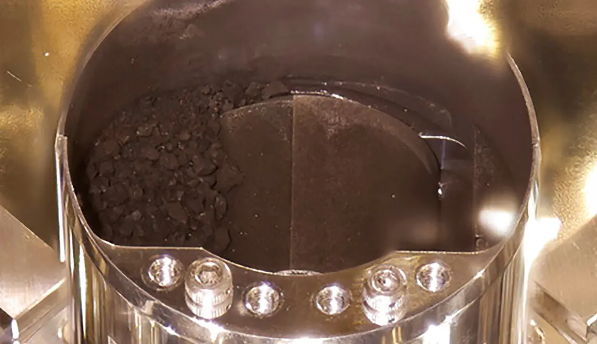 Sampel tanah terlihat dalam wadah kapsul yang dibawa pesawat antariksa Hayabusa2 di Sagamihara, Jepang, Selasa (15/12/2020). Sampel tanah dan gas dikumpulkan dari asteroid Ryugu yang berjarak sekitar 300 juta kilometer dari Bumi. (JAXA via AP)