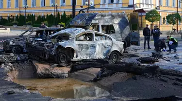 Mobil yang rusak terlihat di lokasi serangan rudal Rusia di Kiev, Ukraina, Senin (10/10/2022). Dua ledakan terdengar di pusat Kiev sekitar pukul 08.00 waktu setempat. (AP Photo/Efrem Lukatsky)