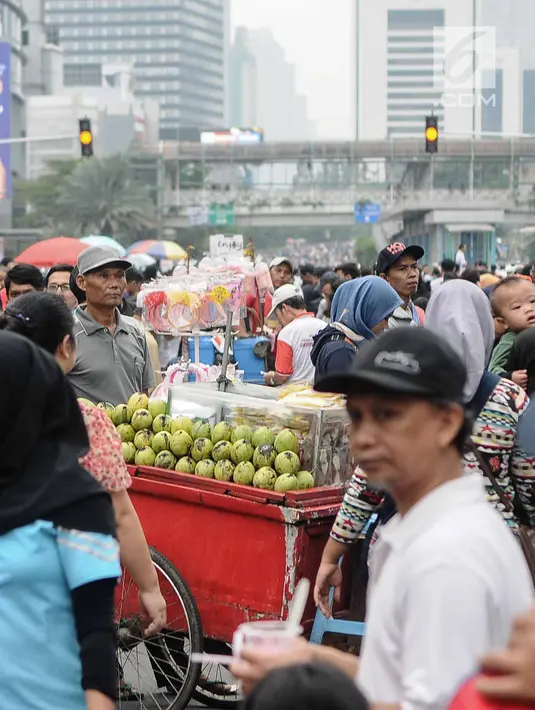 Pedagang Kaki Lima (PKL) berjualan selama kegiatan Car Free Day (CFD) di sepanjang Jalan Sudirman, Jakarta, Minggu (9/12). Kurangnya pengawasan menyebabkan banyak PKL yang berjualan tidak pada tempatnya dan memenuhi area CFD. (Liputan6.com/Faizal Fanani)