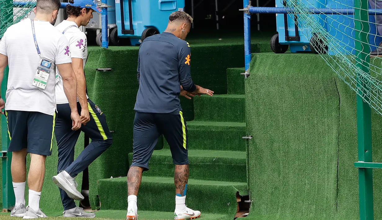Striker Brasil, Neymar meninggalkan sesi latihan setelah merasakan sakit di pergelangan kaki kanannya di Sochi, Selasa (19/6). Neymar berhenti berlatih untuk persiapan pertandingan Piala Dunia kedua timnas Brasil melawan Kosta Rika. (AP/Andre Penner)