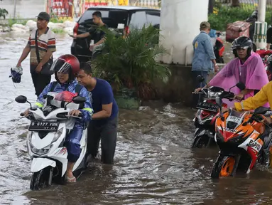 Pengendara terpaksa mendorong motornya yang mogok akibat memaksa melintasi banjir yang menggenangi jalan Ciledug Raya, Jakarta Selatan, Sabtu (6/7/2024). (Liputan6.com/Angga Yuniar)