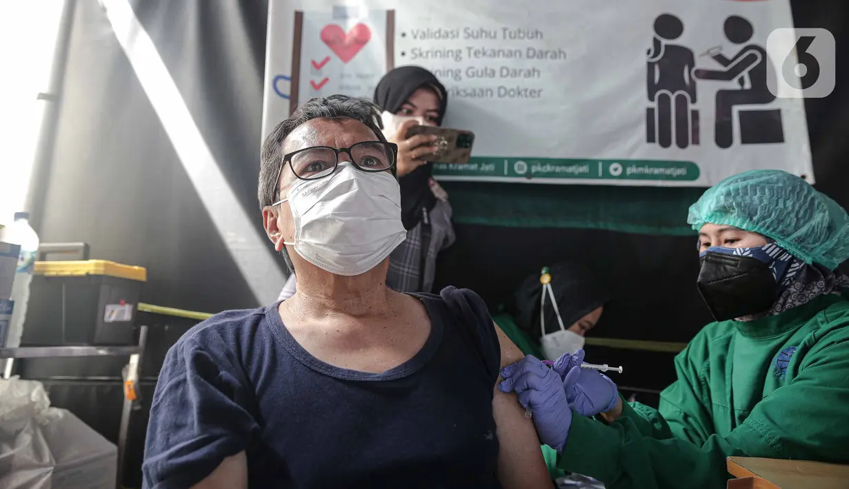 Tenaga kesehatan menyuntikkan vaksin COVID-19 dosis ketiga kepada warga di Puskesmas Kecamatan Kramat Jati, Jakarta, Rabu (12/1/2022). Program vaksinasi lanjutan (booster) COVID-19 diberikan kepada kelompok prioritas yaitu lanjut usia dan penderita immunokompromais. (Liputan6.com/Faizal Fanani)