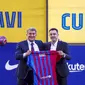Pelatih baru FC Barcelona Xavi Hernandez (kanan) berpose di samping presiden Joan Laporta selama presentasi resminya di stadion Camp Nou di Barcelona, Spanyol, Senin (8/11/2021). (AP Photo/Joan Monfort)
