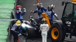 Pembalap Mercedes, Lewis Hamilton keluar dari mobilnya usai menabrak saat kualifikasi F1 GP Brasil di sirkuit Interlagos di Sao Paulo, Brasil (11/11). Hamilton juga tidak dapat menyelesaikan kualifikasi GP Brasil. (AFP Photo/Nelson Almeida)