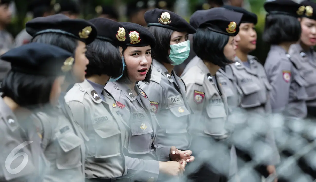 Polisi wanita (Polwan) bersiaga mengamankan aksi 31 Maret di kawasan Jalan Merdeka Barat, Jumat (31/3). Polwan dari Brimob Polda Metro Jaya itu berdiri tak jauh dari kawat berduri, yang memisahkan peserta aksi dengan Polisi. (Liputan6.com/Faizal Fanani)