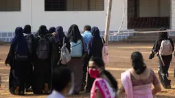 Sejumlah siswi tiba di kampus mereka di Udupi, India (7/2/2022). Dilaporkan ABC News, Selasa (8/2/2022), protes yang terjadi tak membuat staf sekolah tergerak terhadap aksi para murid yang protes di gerbang sekolah yang berlokasi di distrik Udupi. Sekolah itu merupakan milik pemerintah. (AP Photo)