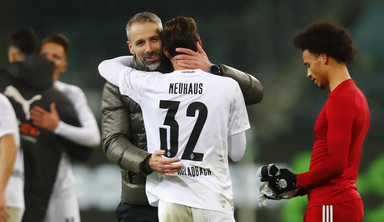 Manajer tim Borussia Moenchengladbach, Marco Rose bersama gelandang Florian Neuhaus merayakan kemenangan 3-2 atas Bayern Munich usai berakhirnya laga lanjutan Liga Jerman 2020/21 pekan ke-15 di Borussia Park, Jumat (8/1/2021). (AFP/Wolfgang Rattay/Pool)