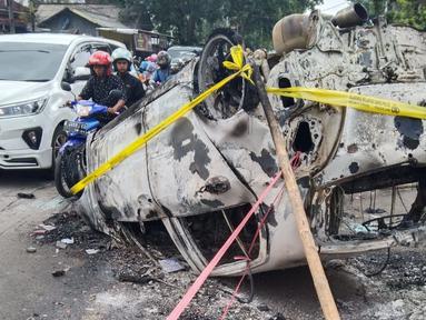 Bangkai mobil yang terbakar di luar Stadion Kanjuruhan, Malang, turut menjadi saksi bisu tragedi mengerikan yang merenggut ratusan nyawa orang. (Bola.com/Iwan Setiawan)