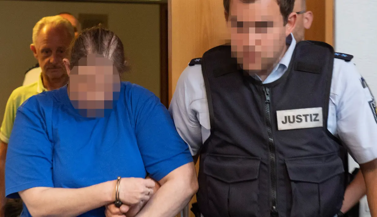 Terdakwa Berrin T (kiri) memasuki ruangan sebelum sidang putusan di pengadilan distrik di Freiburg, Jerman, Selasa (7/8). Berrin dan suami divonis penjara 12 dan 12,5 tahun. (THOMAS KIENZLE/AFP)