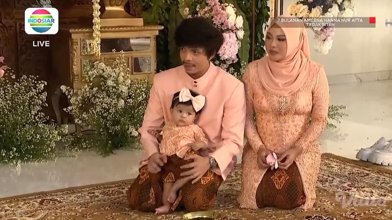 Atta Halilintar dan Aurel Hermansyah mendampingi putri mereka Ameena Hanna Nur Atta menjalani upacara Tedak Siten di acara 7 bulanan. (Foto: Indosiar/Vidio)