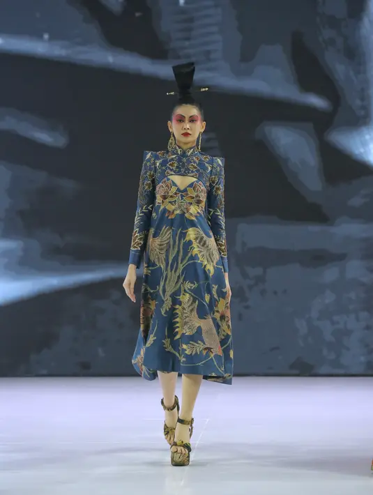 Pertama, seri Asmaradana, yang berfokus pada kreasi citra pakaian Cheongsam. Elemennya berupa kerah-kerah tinggi, baik itu pada blus berbahan renda putih atau vest penuh ornamentasi atau pilihan outerwear ala gaun cocktail berhiaskan batik Kudus, motifnya dibuat cantik dan bold. [Foto: Document/FIMELA]