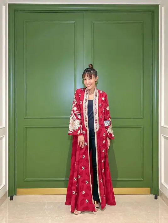 Ayu Dewi memakai dress yang dibuka sebagai outerwear. Yang memberikan look lebih kasual. Warna merah membuat tampilannya makin menonjol. [Foto: @mrsayudewi]