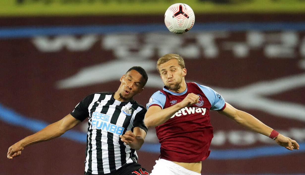 Pemain Newcastle United, Isaac Hayden, duel udara dengan pemain West Ham United, Tomas Soucek, pada laga Premier League di Stadion London, Minggu (13/9/2020). Newcastle United menang dengan skor 2-0. (Adam Davy/Pool via AP)