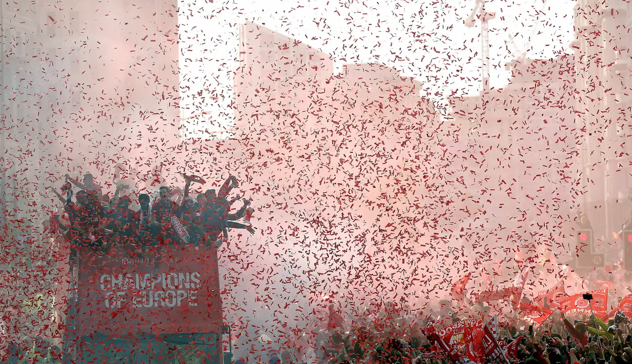 Pemain Liverpool menyapa para suporter saat parade juara Liga Champions di Liverpool, Inggris (2/6/2019). Ribuan suporter tumpah ruah di jalanan merayakan kemenangan tim kesayangannya meraih piala Liga Champions usai mengalahkan Tottenham di final dengan skor 2-0. (Barrington Coombs/PA via AP)