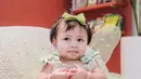 Sambil berpose melet, baby Lily mengenakan dress tutu dengan pita berwarna hijau pastel Rp835 ribuan [@raffinagita1717]