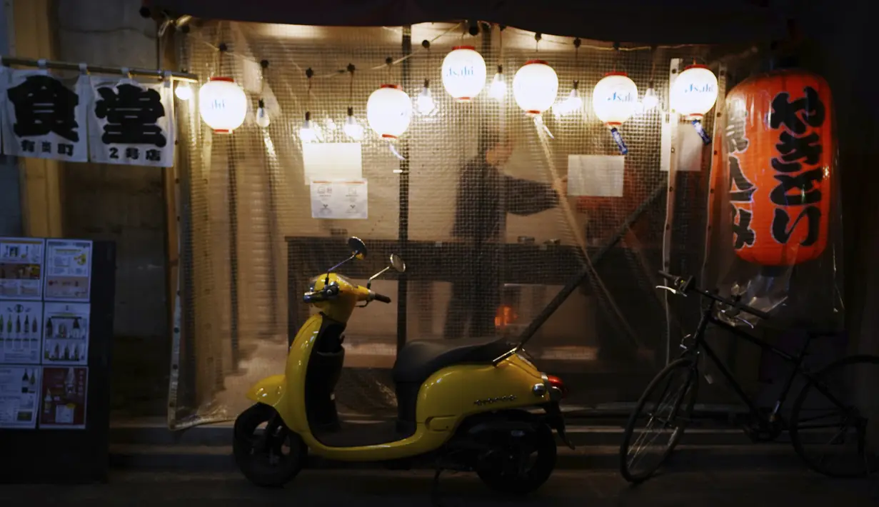 Pelanggan minum di bar di Tokyo(7/1/2021). Pembatasannya berpusat pada langkah-langkah untuk memerangi penularan di bar dan restoran, yang disebut oleh pemerintah sebagai area berisiko utama. (AP Photo/Eugene Hoshiko)