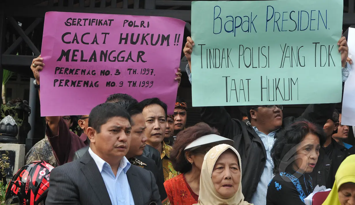 Warga perumahan Pati Polri membentangkan tulisan berisi pesan kepada Presiden Joko Widodo menolak penggusuran rumah mereka di Cipinang Baru Bunder, Jakarta, Selasa (26/5/2015). (Liputan6.com/Herman Zakharia)