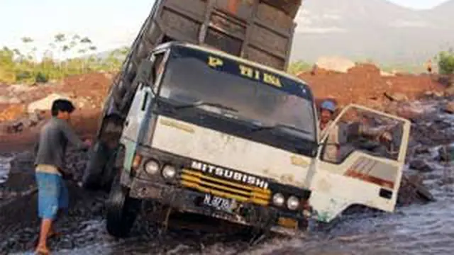 Sopir dan kernetnya berupaya mengevakuasi truk yang terjebak banjir lahar dingin dari puncak Gunung Semeru di aliran lahar Besuk Sat, Lumajang, Jatim, Kamis (23/9). (Antara)