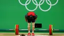 Atlet angkat besi Indonesia Triyatno membungkuk usai mengangkat beban  di kelas 69 kg putra pada Olimpiade Rio 2016, Rabu (10/8). Gagal mempertahankan medali perak, atlet kelahiran Lampung itu hanya berada di peringkat delapan. (REUTERS/Yves Herman)