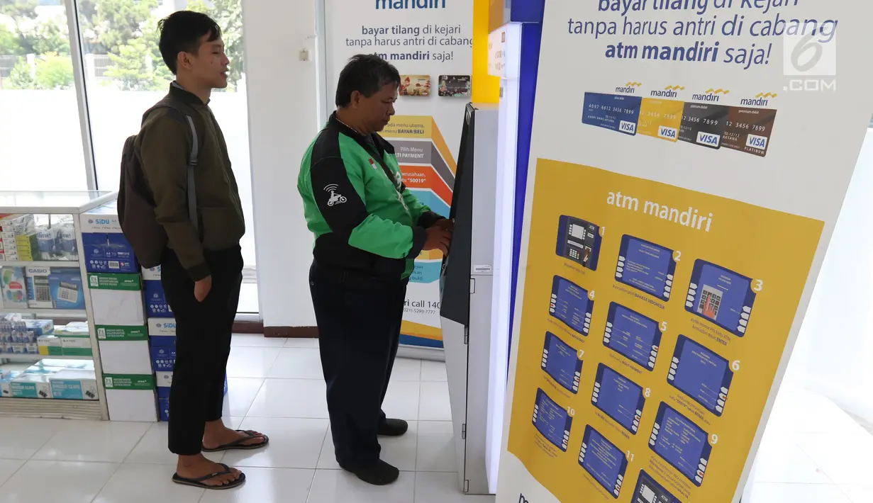 Warga melakukan transaksi pembayaran tilang online melalui atm Bank Mandiri di Jakarta, Kamis (3/1). Bank Mandiri berkerjasama dengan Kejari Jakpus dalam penerimaan pembayaran tilang non tunai atau secara online. (Liputan6.com/Angga Yuniar)