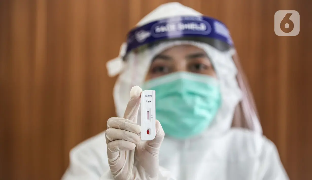 Petugas medis menunjukkan hasil rapid test penumpang di Stasiun Pasar Senen, Jakarta, Senin (27/7/2020).  Penyediaan layanan Rapid Test merupakan bentuk peningkatan pelayanan KAI dalam rangka menerapkan protokol kesehatan yang ketat pada moda transportasi kereta api. (Liputan6.com/Faizal Fanani)