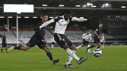 Pemain Fulham Andre-Frank Zambo Anguissa (tengah) menendang bola saat pemain Manchester City Gabriel Jesus mendekatinya pada pertandingan Liga Inggris di Stadion Craven Cottage, London, Inggris, Sabtu (13/3/2021). Manchester City menang 3-0. (Catherine Ivill/Pool via AP)
