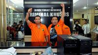 Dua dari tiga admin twitter @TrioMacan2000, Raden Nuh (kiri) dan Edi Syahputra berteriak saat mengikuti rilis di Direktorat Reserse Kriminal Khusus Polda Metro Jaya, Jakarta, Senin (3/11/2014). (Liputan6.com/Andrian Martinus Tunay)