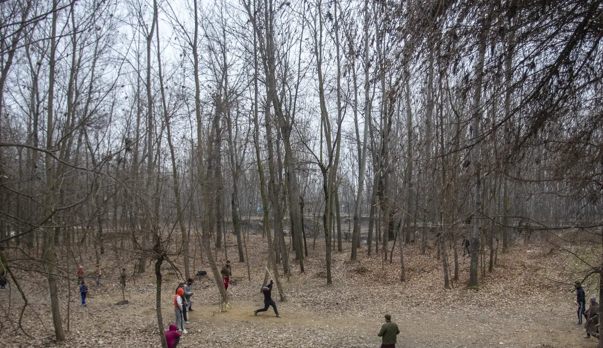 Anak laki-laki Kashmir bermain kriket pada hari yang dingin di pinggiran Srinagar, Kashmir yang dikuasai India, Senin (27/12/2021). (AP Photo/Mukhtar Khan)