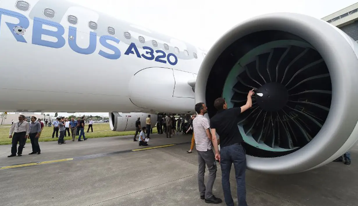 Dua orang staff produsen Airbus A320neo melihat-lihat mesin pesawat sebelum dilakukan uji jarak menengah di pabrik Airbus, Saint-Martin-du-Touch, Toulouse, Perancis, (1/7/2014). (AFP PHOTO/ERIC Cabanis)
