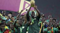Para pemain Senegal merayakan dengan trofi setelah memenangkan pertandingan final Piala Afrika 2022 atas Mesir di Paul Biya Stadium, Kamerun, Senin (7/2/2022) dini hari WIB. Sadio Mane membawa Senegal mengalahkan Mesir lewat adu penalti dengan skor 4-2. (AP Photo/Sunday Alamba)