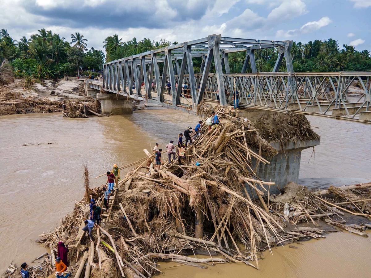 FOTO: Warga Memanjat Puing Kayu Demi Menyeberangi Sungai Peusangan