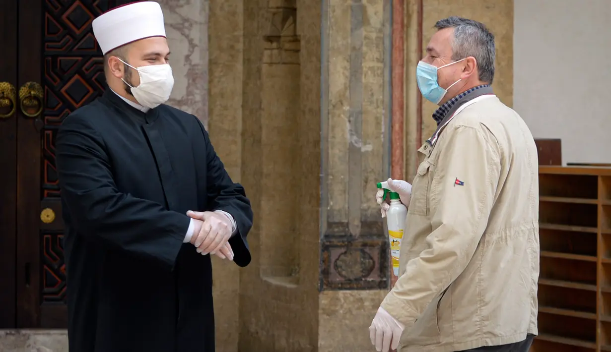 Orang-orang dengan mengenakan masker berbincang di masjid Begova, Sarajevo, Rabu (6/5/2020). Setelah hampir dua bulan dikurung, Bosnia membuka kembali masjid-masjid untuk Umat Muslim yang merayakan bulan Ramadan dengan tetap mematuhi jarak sosial dan menggunakan peralatan pelindung (AP/Kemal Softic)