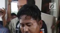 Pelaku pembunuhan wartawan Abdullah Fitri Setiawan yang tewas dalam drum M Nurhadi digiring petugas di Bogor di Polda Metro Jaya, Jakarta, Rabu (21/11). Kedua pelaku dijerat pasal pembunuhan berencana dan terancam hukuman mati. (Merdeka.com/Imam Buhori)