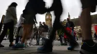 Pejalan kaki melintas di sekitar menara jam Big Ben yang mulai membisu di Elizabeth Tower, London, Senin (21/8). Membisunya Big Ben kali ini merupakan yang pertama kali setelah terakhir kali terjadi pada 157 tahun yang lalu. (BEN STANSALL / AFP)