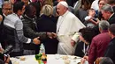Paus Fransiskus tiba untuk menghadiri makan siang bersama sejumlah orang miskin di Pope Paul VI, Vatikan, Minggu (18/11). Makan siang bersama ratusan kaum papa, tunawisma, dan pengangguran itu memperingati Hari Orang Miskin Sedunia. (Vincenzo PINTO/AFP)