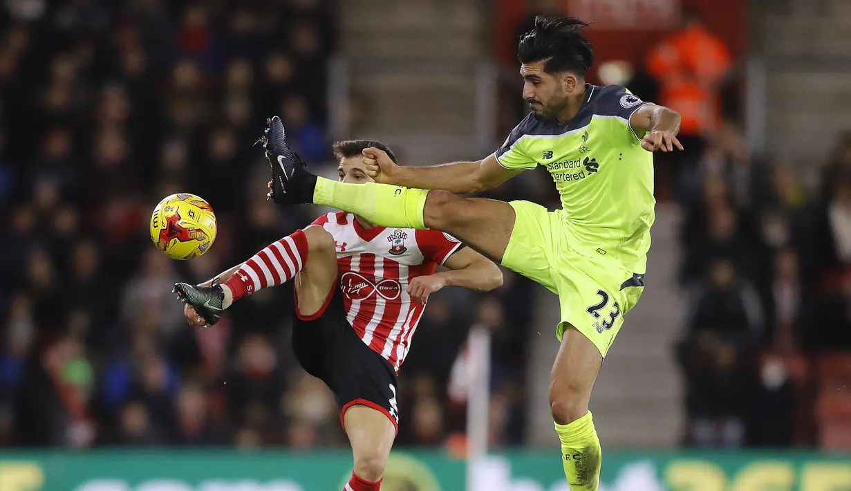 Pemain Southampton, Cedric (kiri) dan pemain Liverpool, Emre Can berebut bola pada laga leg pertama Semifinal Piala Liga Inggris di St. Mary's stadium, Southampton (11/1/2017). Soton menang 1-0 atas Liverpool. (AP/Frank Augstein)