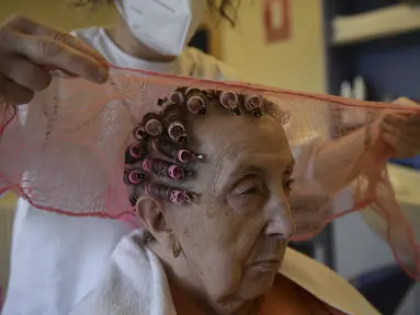 Maribel Elizondo, 90 tahun, ditata rambutnya oleh penata rambut Gloria Cerdan di salon rambut di panti jompo Ibaneta, sekitar 30 km dari Pamplona, Spanyol, Senin (22/3/2021). Setiap minggu, pada hari Senin, penata rambut Gloria Cerdan mendatangi penghuni panti jompo. (AP Photo/Alvaro Barrientos)