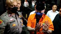 Penampakan mantan Kapolda Sumbar Irjen Teddy Minahasa memakai baju tahanan berwarna oranye dengan tangan diborgol saat dijebloskan ke Rutan Polda Metro Jaya. (Merdeka.com)
