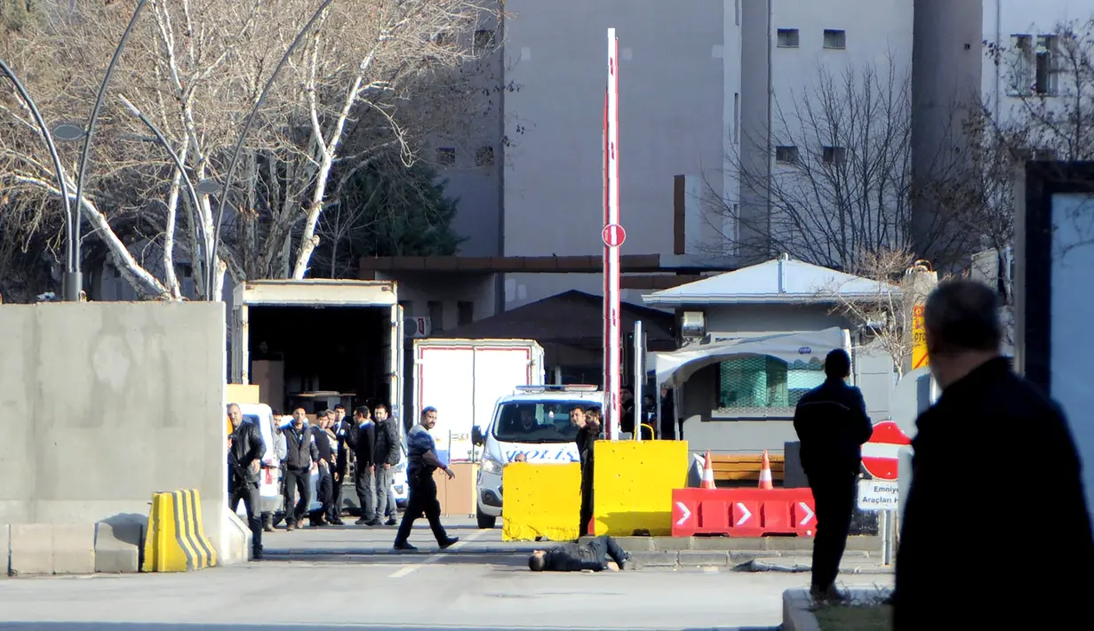 Seorang pria tergeletak di tanah setelah ditembak mati oleh petugas, di luar kantor polisi di Gaziantep, Turki, Selasa (10/1). Pria itu ditembak mati, setelah sebelumnya secara tiba-tiba penyerang menembakkan senjatanya ke arah polisi. (AFP PHOTO/STR)