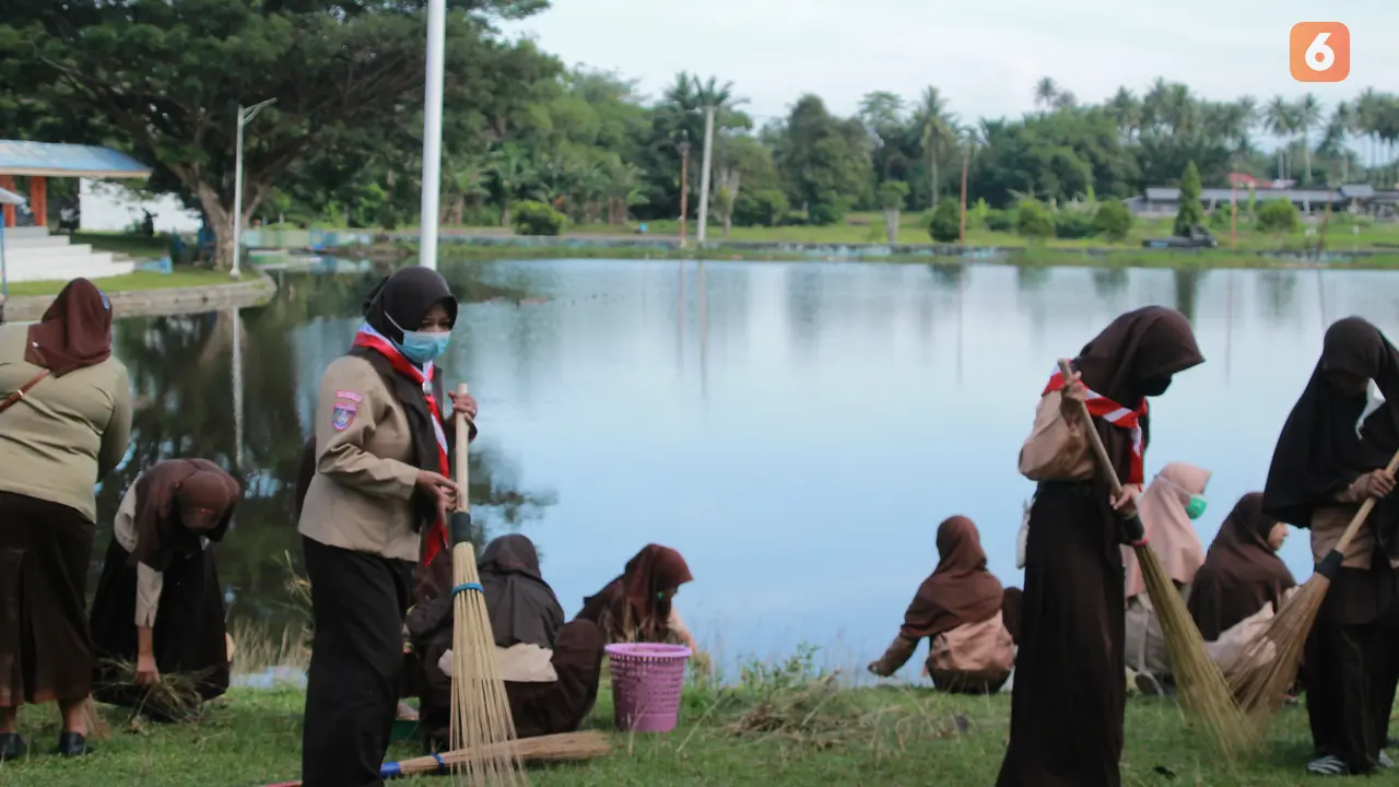 Sejumlah siswa sekolah dasar membersihkan bantaran danau perintis