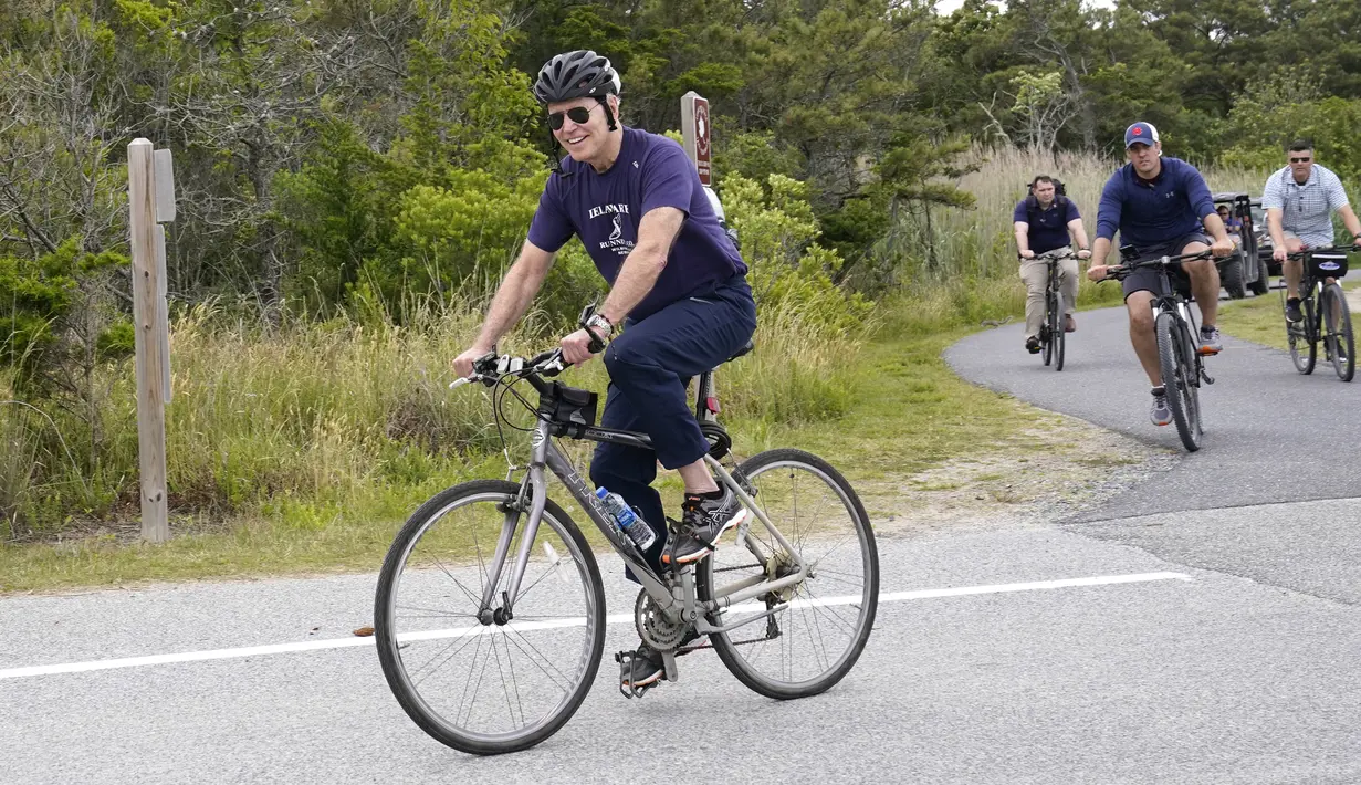 Presiden Joe Biden dengan ibu negara, Jill Biden (tidak terlihat) bersepeda di Pantai Rehoboth, Delaware, Kamis (3/6/2021). Mereka bersepeda sekaligus untuk merayakan ulang tahun ke-70 ibu negara Amerika Serikat. (AP Photo/Susan Walsh)