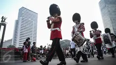 Scotts Guard alias penjaga Buckingham Palace melakukan aksi mengelilingi di Bundaran HI, Jakarta, Minggu (5/6). Aksi Scotts Guard yang didatangkan dari Inggris ini dalam rangka hari ulang tahun Ratu Elizabeth II yang ke-90. (Liputan6.com/Faizal Fanani)
