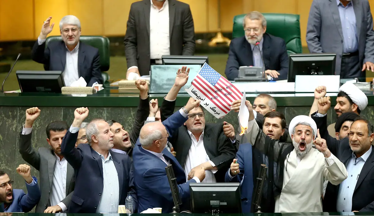Detik-detik anggota parlemen Iran membakar dua lembar kertas bergambar bendera AS, Teheran, Iran, Rabu (9/5). Donald Trump menarik AS dari kesepakatan Nuklir Iran dan akan memberlakukan kembali sanksi terhadap Teheran. (AP Photo)